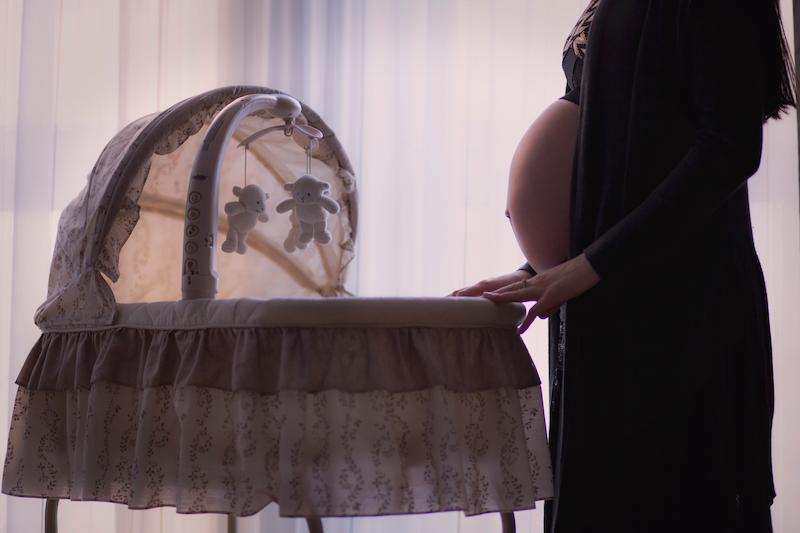 Беременная женщина у детской кроватки